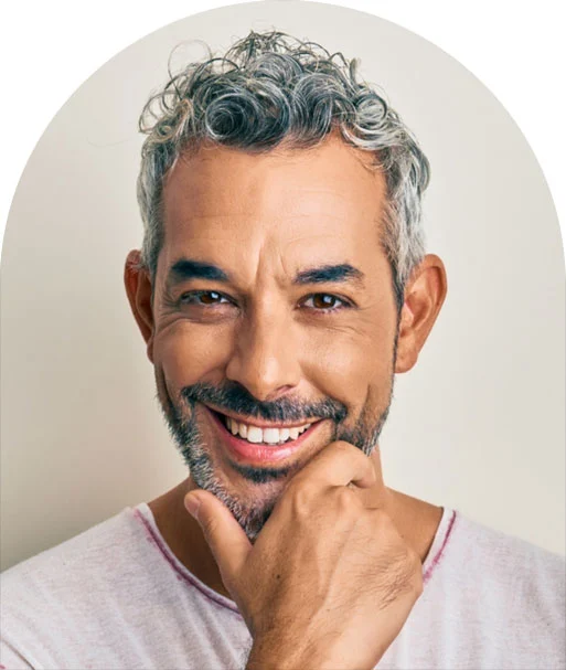 A man with grey hair and beard smiling