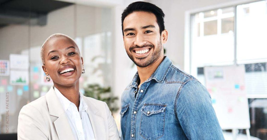 Smiling man and woman standing together (models), representing readiness for a first Botox appointment